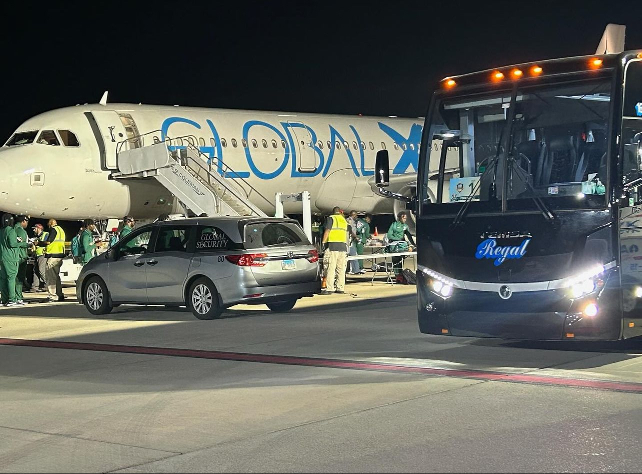 Plane, bus, and security vehicles at airport.